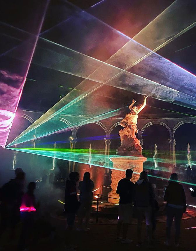 Photo of the bosquet des colonnades in Versailles with lasers projected around the statue in the middle