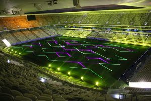 Photo of a stadium with splashes of green and purple geometric shapes on it