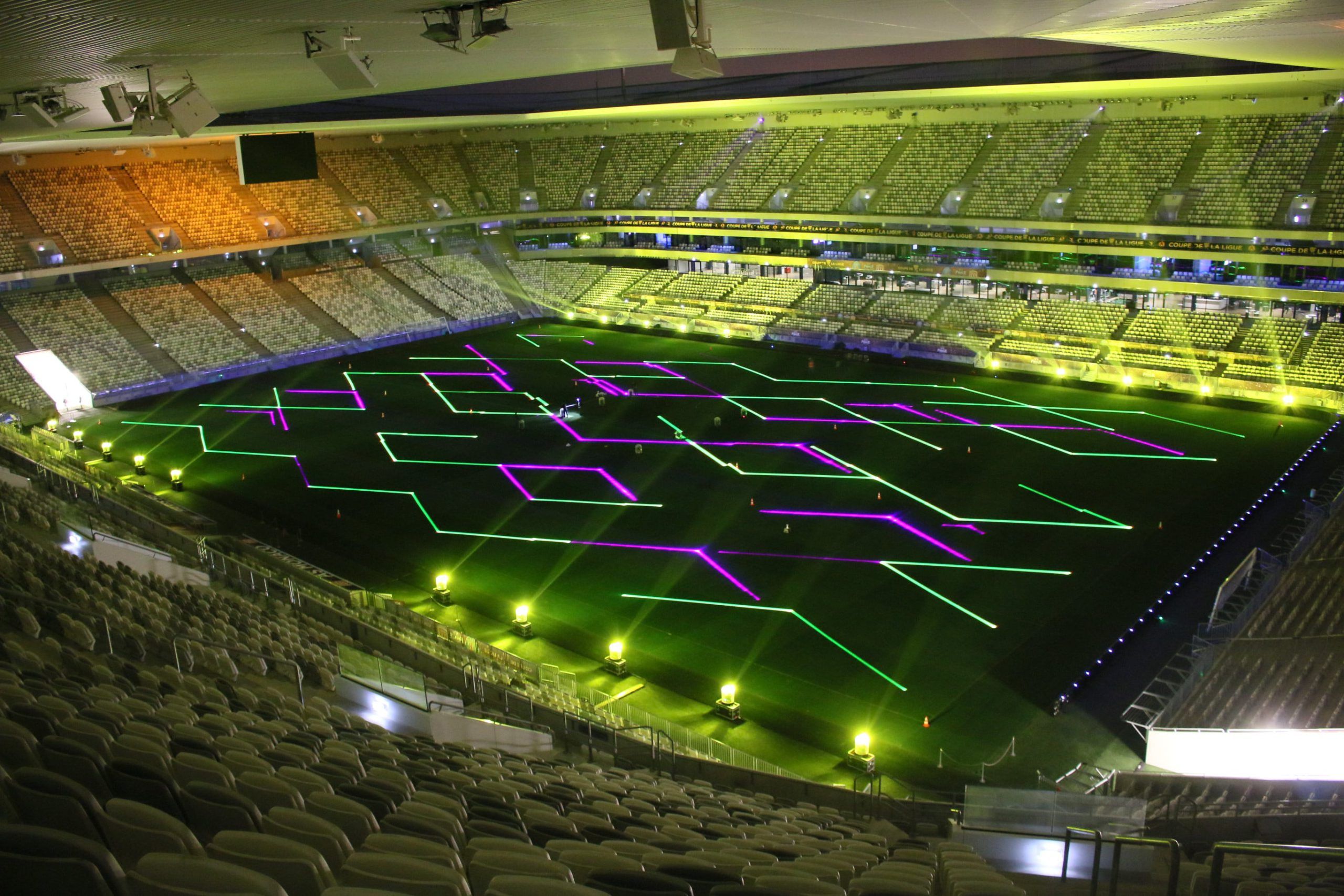 Animations projections - Photo of a stadium with splashes of green and purple geometric shapes on it