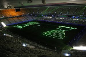 Photo of a stadium with a green league cup logo projected