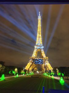 Photo of the Eiffel Tower with a laser projection of a hydrogen logo in the middle