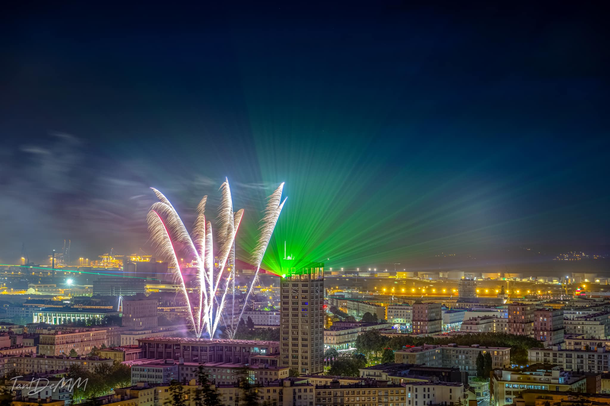 Photo of a tower with projection of fireworks and green laser beams