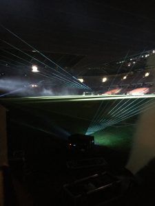 Photo of a stadium with laser beams projected skyward