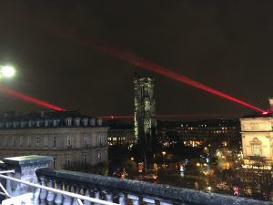 Photo of red laser beams passing around a church