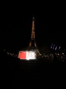 Photo of dates projected onto a screen of water in front of the Eiffel Tower