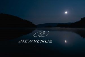 Photo of a lake with Welcome text projecting onto it and a leaf logo