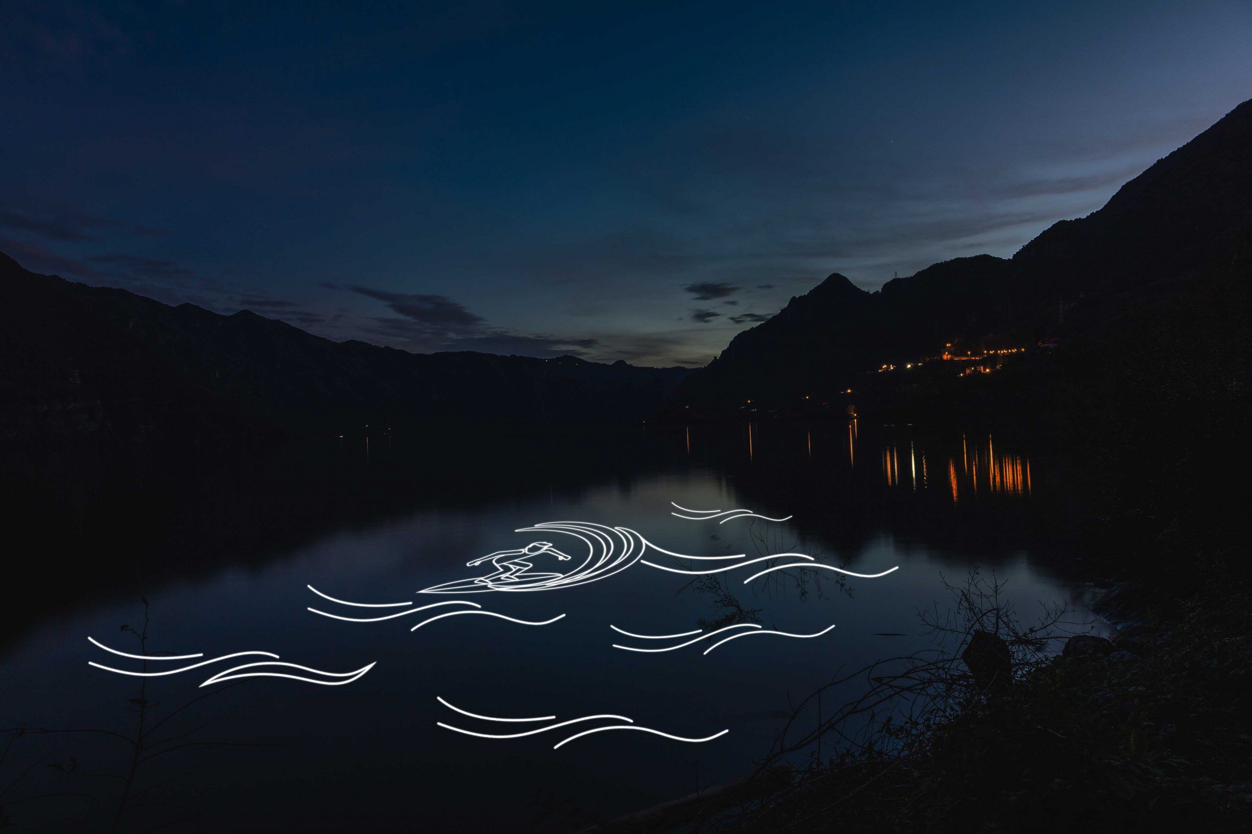 Photo of a lake with laser projection of wave shapes and surfer on it