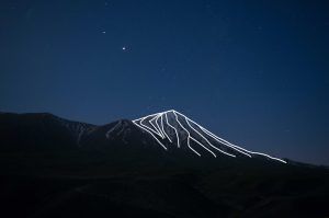 Photo of a mountain with laser projection of strokes in order to highlight its reliefs