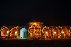 Photo of a caravanserai with projection of mosaic shapes on it and tracing of the outlines of the openings