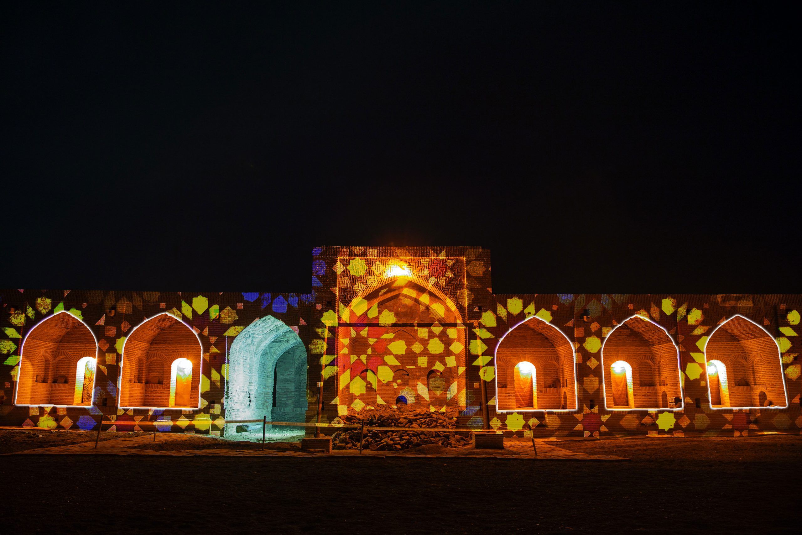 Europe Évènement - Photo of a caravanserai with projection of mosaic shapes on it and tracing of the outlines of the openings