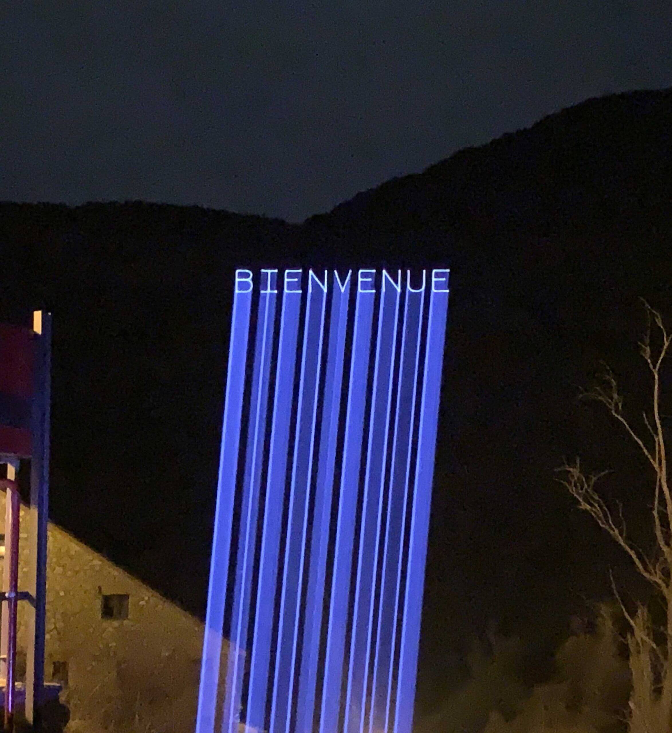 Europe Évènement - Photo d'une projection de texte disant Bienvenue en bleu sur une montagne
