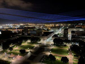 Europe Évènement - Signalétique - Photo d'une ville avec faisceaux lasers bleus passant au-dessus au Havre