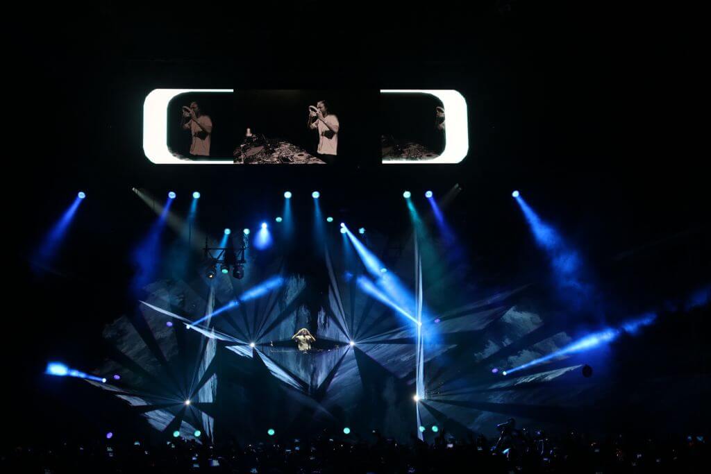 Europe Évènement - Photo d'un concert du DJ David Guetta avec faisceaux lasers et lumières bleus autour de lui